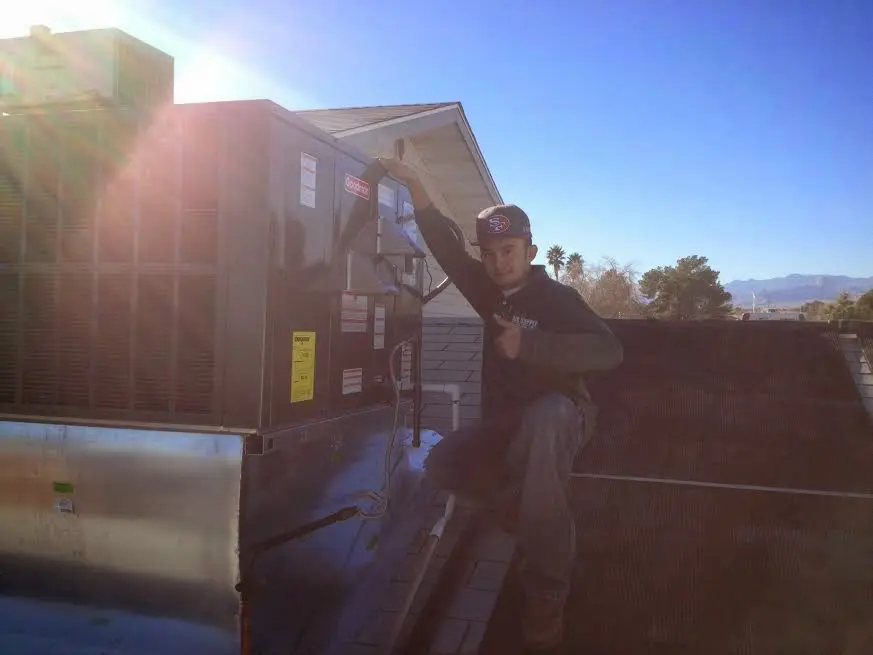 HVAC technician performing AC Tune-Up on a rooftop unit in Tipp City